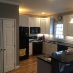 Renovated kitchen with new cabinets,  quartz countertop, backsplash tile and paint